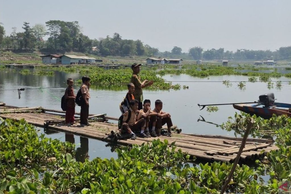 Siswa Bandung Barat menyeberangi Waduk Saguling menggunakan rakit bambu untuk pergi ke sekolah.